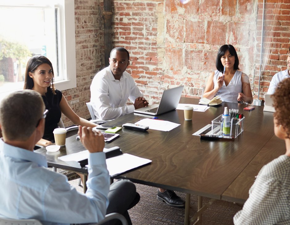 People gathered at a conference table discussing a design