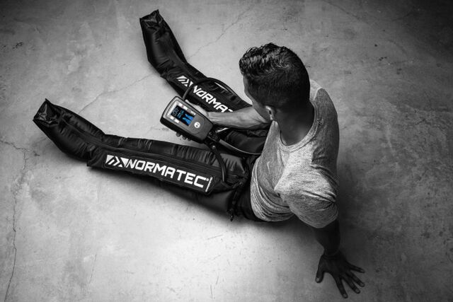 Photograph of a person wearing NormaTec recovery boots